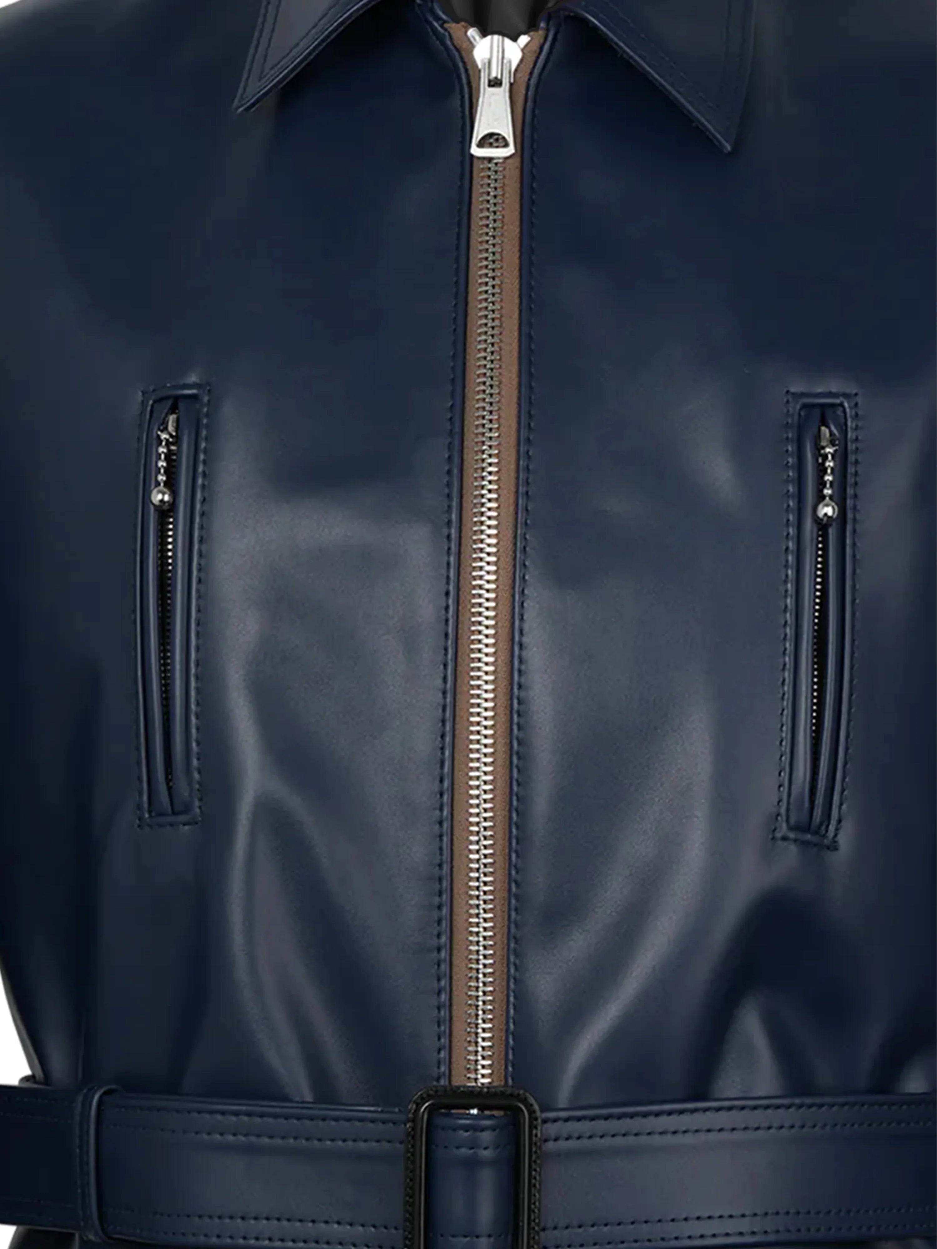 Close-up of a navy blue leather jacket with a zipper and belt.