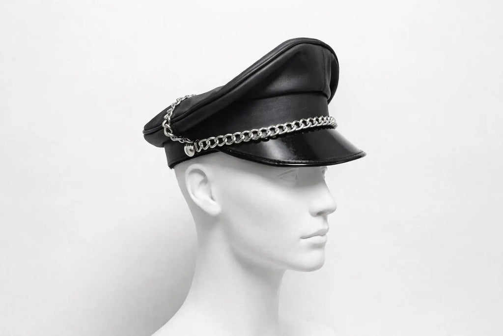 Black leather cap with chain detail on a mannequin head against a white background
